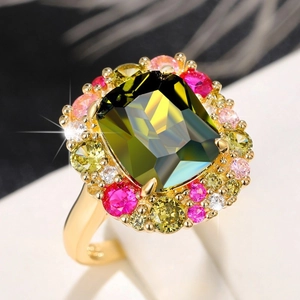 Vista macro de un anillo de esmeralda rectangular con pavé de gemas de colores en oro