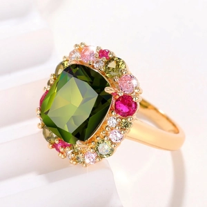 Primer plano de gema verde esmeralda con piedras pavé de colores en un anillo dorado