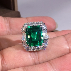 Luxurious geometric ring with emerald cut green stone and silver band setting