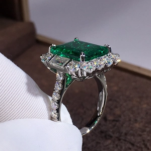 Luxury emerald cut green gemstone ring with halo diamonds on white gold band