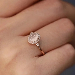 French vintage rose gold ring with oval pink gemstone and halo zircon setting