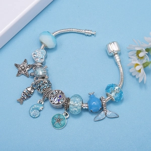 Ocean themed charm bracelet with blue glass beads and starfish pendants on silver snake chain