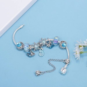 Silver ocean charm bracelet featuring blue glass beads and sea turtle pendants