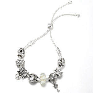Silbernes Schlangenarmband mit Kristallperlen und Herz-Schlüssel-Anhänger auf Weiß