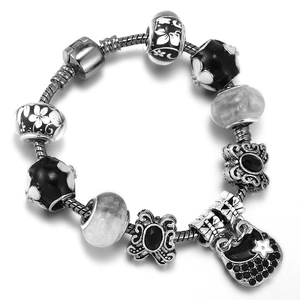 DIY black glass charm bracelet featuring butterfly and handbag charms on snake chain