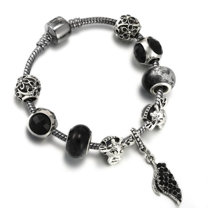 Silver snake chain bracelet featuring black faceted beads and giraffe charms on white background