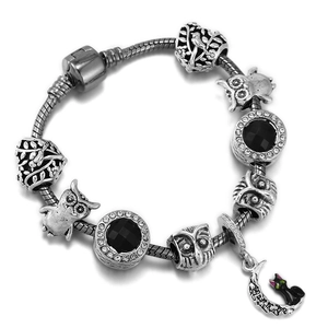 Silver snake chain bracelet featuring black gemstones, owl charms and crescent moon cat pendant