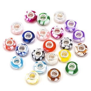 Macro shot of colorful resin beads with checkered patterns and silver metal cores for DIY