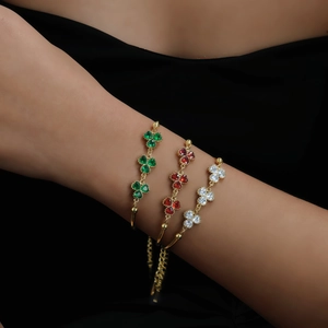 Three-color clover bracelets with crystals on golden adjustable chains worn by a model