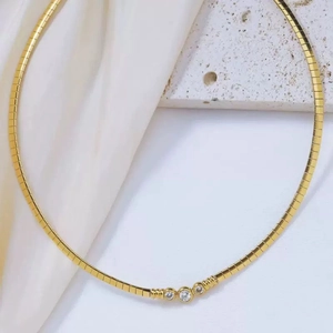 Close-up of gold titanium steel snake chain featuring three inlaid sparkling zircons