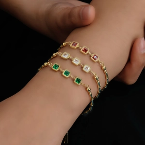 Golden bamboo chain bracelet with colorful square crystals on a female model's wrist