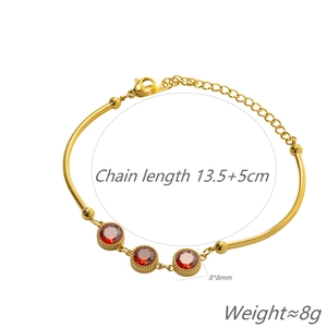 Detail of gold bamboo chain bracelet featuring red gemstones and lobster clasp closure