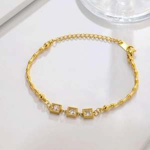 Detail of gold bamboo chain bracelet with three square cubic zirconia accents