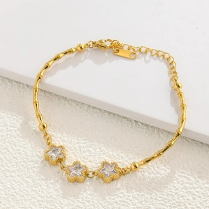 Detailed view of a gold bamboo link bracelet featuring three star-shaped zircon stones