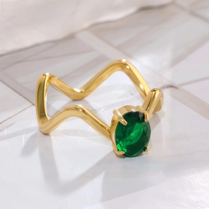 Bague vague dorée ornée d'une pierre précieuse vert émeraude ovale sertie à quatre griffes