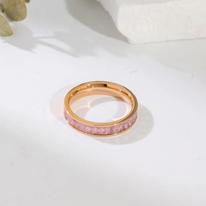 Detail shot of rose gold titanium ring with pink square-cut zirconia inlay on white stone