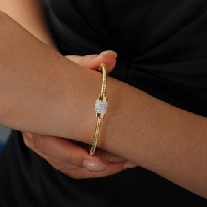 Detail of rose gold bangle featuring pave-set crystal center on snake bone chain