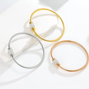 Detailed view of snake bone textured bracelets in gold, silver, and rose gold finishes