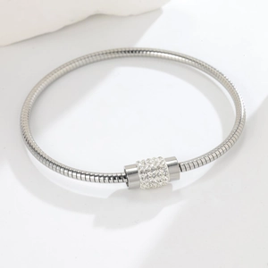 Macro detail of silver snake chain bracelet with sparkling crystal paved cylinder bead