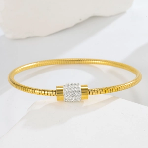 Macro view of rose gold snake chain bracelet featuring a pavé white crystal centerpiece