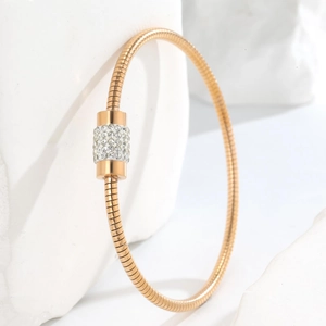 Macro shot of rose gold snake chain bracelet featuring a sparkling paved crystal clasp