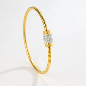 Detail of rose gold bangle with snake bone texture and crystal encrusted cylinder charm