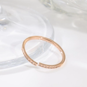 Elegant rose gold titanium steel ring with sparkling pavé zircons on white background