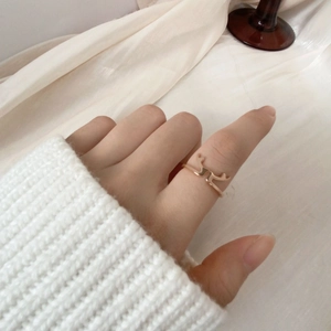 Anello corna d'oro rosa indossato con un maglione bianco in stile invernale