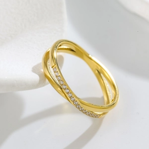 Macro view of interwoven gold-plated band with micro-pave zirconia setting