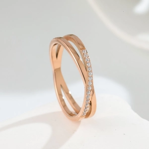 Detailed macro of rose gold criss cross ring with sparkling cubic zirconia pavé setting