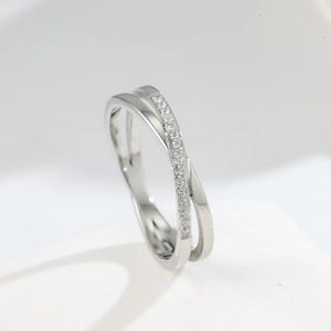 Macro shot of silver crisscross ring featuring polished finish and micro-pave crystals