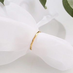 Anillo de onda minimalista en acero de titanio dorado de 1mm sobre elegante tela de malla blanca