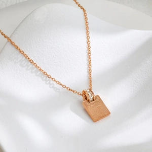 Collana in titanio oro rosa con anello di diamanti e ciondolo quadrato con scritta