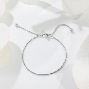 Adjustable silver stainless steel snake chain bracelet with bolo closure on white background