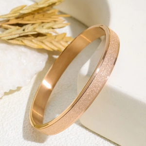 Rose gold matte frosted stainless steel bracelet for women shown on a white luxury display