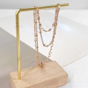 Double-layered 18k rose gold stainless steel bracelet with sparkling leaf and bead charms