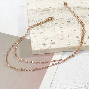Detail of rose gold double-layered bracelet with lobster clasp and extension chain