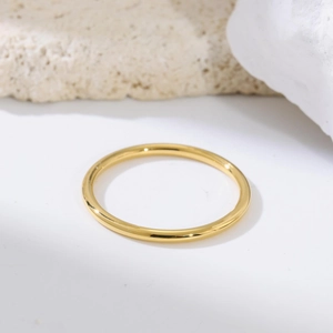 Gros plan sur une bague fine de 1,5 mm en acier doré poli au design minimaliste
