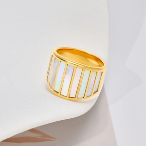 Detail van gouden brede ring met rechthoekige inlays van wit parelmoer