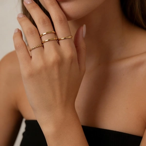 Close-up of gold titanium steel ring set with faceted and diamond-patterned bands