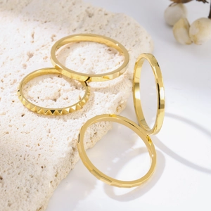 Set of four minimalist gold-plated titanium steel rings featuring faceted and studded designs