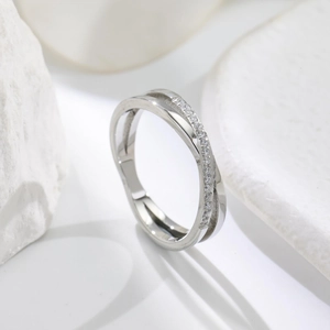 Detailed view of silver criss-cross ring with pavé diamond accents on stone