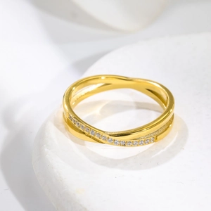 Macro shot of rose gold criss cross ring featuring a row of white pavé set diamonds