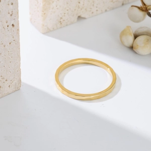 Detailed view of faceted gold stainless steel ring on natural stone background