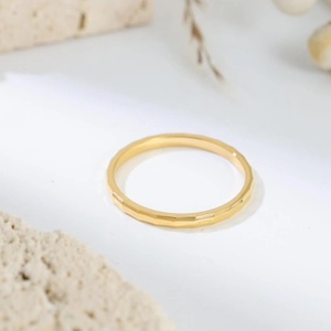 Detailed view of the faceted golden stainless steel ring showing geometric light reflections