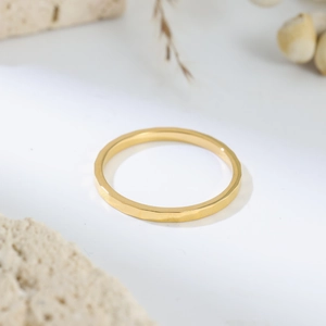 Close-up of golden titanium ring with hammered mosaic facets on white stone
