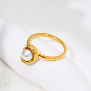 Detailed view of an elegant gold titanium ring featuring a bezel-set white pearl shell