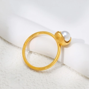 Elegant gold titanium ring featuring a round white pearl on a matte finish band