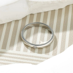 Detailed close-up of a silver titanium steel ring with a single small sparkling crystal