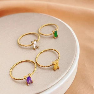 Set of four gold stainless steel twisted rings with rectangular colorful gemstones